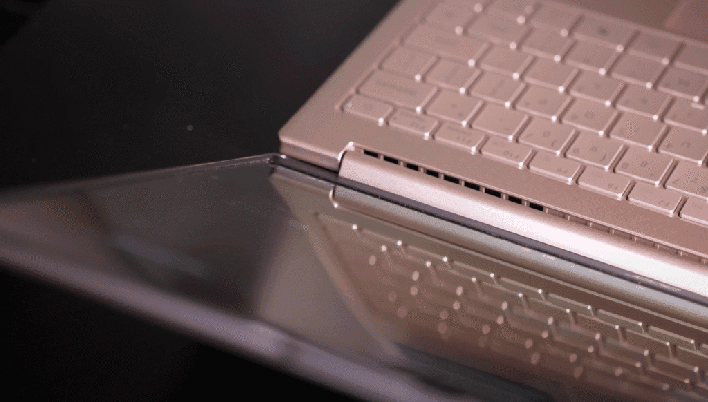 Close-up of the Acer laptop’s hinge and keyboard design with screen reflection on a glossy surface.