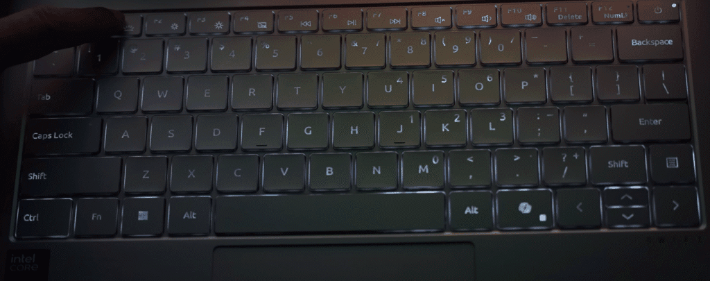 Acer Swift laptop keyboard with white backlit keys and a user adjusting brightness using the top function key row.