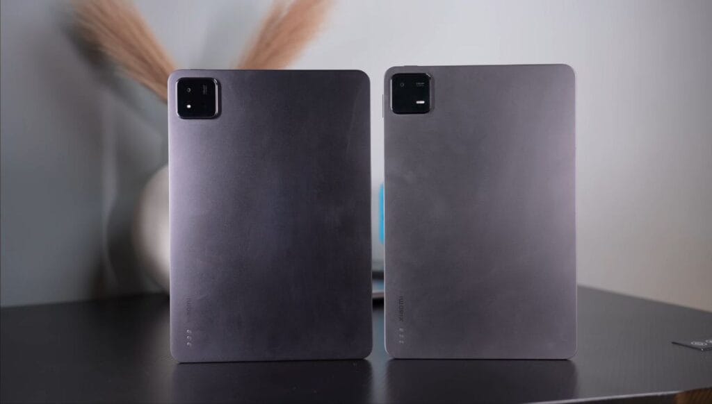 Two Xiaomi Pad 7 tablets placed side by side on a table, showing their rear design and camera modules in the top left corner